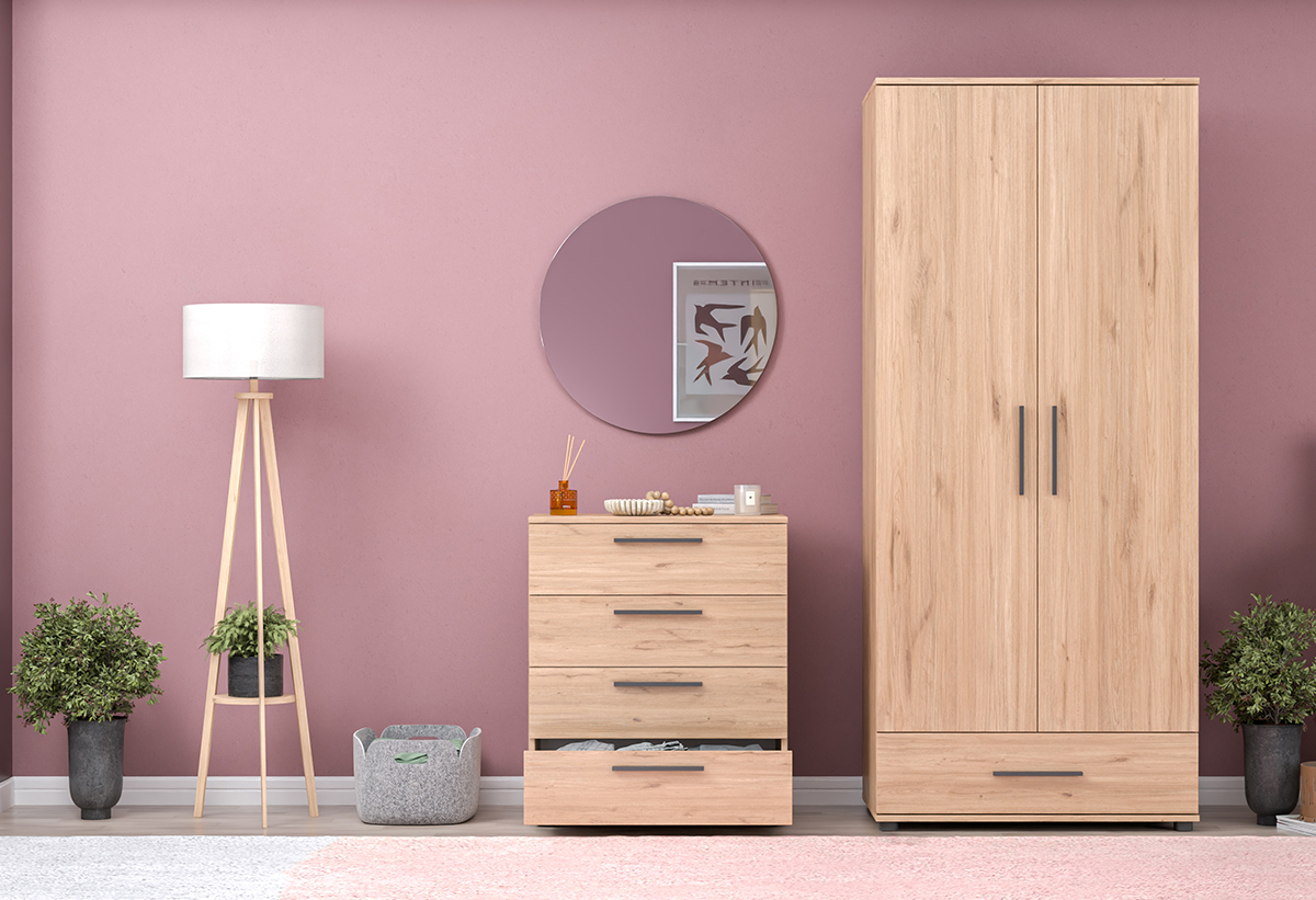 Απεικονίζεται η συρταριέρα μέσα σε υπνοδωμάτιο μαζί με άλλα έπιπλα και αντικείμενα.